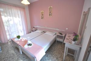 リメナリアにあるstudio ermioni fresh 2のピンクの壁のベッドルーム1室(大型ベッド1台付)