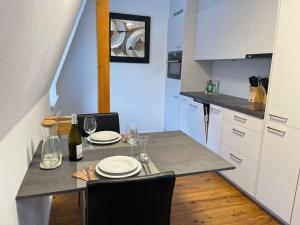 una cocina con una mesa con platos y copas de vino en Tolles Studio im Zentrum von Rapperswil en Rapperswil-Jona