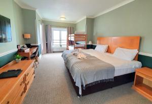 a hotel room with a large bed and a desk at The Wellington in Ventnor