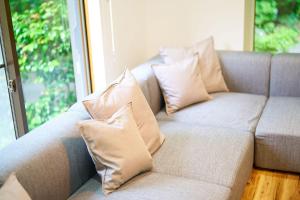 un sofá con almohadas frente a una ventana en Villa Fuji-fumoto -富士宮 麓のヴィラ- 
