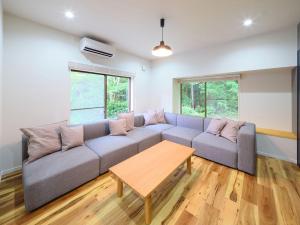 sala de estar con sofá y mesa en Villa Fuji-fumoto -富士宮 麓のヴィラ- 