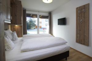 A bed or beds in a room at Ski & Golf Suites Zell am See by Alpin Rentals - incl Summercard