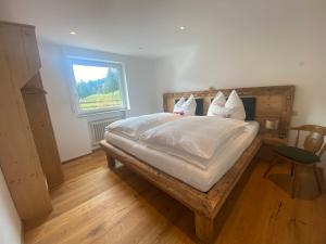 sypialnia z łóżkiem z białą pościelą i oknem w obiekcie Gipfel Stuben w mieście Blaichach