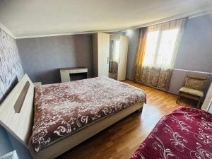 1 dormitorio con 1 cama y 1 silla en Tamuna apartment, en Tiflis