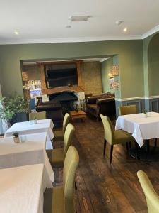 a restaurant with tables and chairs and a piano at The Wellington Hotel - B&B in Ventnor