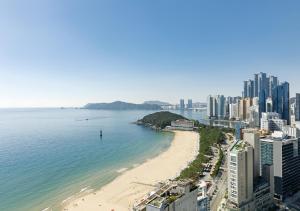 vistas a una playa con edificios y al océano en Sun Cloud Hotel, en Busan