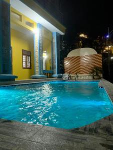 a large blue swimming pool at night with a house at Pra-Ha Villa in Tam Ðảo