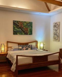 een slaapkamer met een bed en een schilderij aan de muur bij Villa MountainView Guesthouse in Dimiao