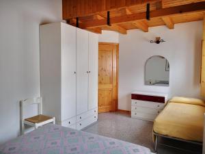 1 dormitorio con armarios blancos, 1 cama y espejo en Giò Appartamenti Vacanze, en Aymavilles