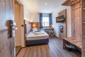 ein Hotelzimmer mit einem Bett und einem TV in der Unterkunft BinderS Budget City-Mountain Hotel in Innsbruck