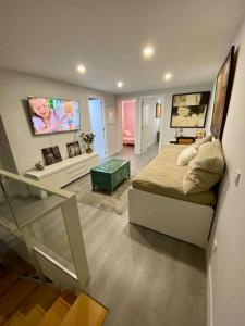 1 dormitorio con 1 cama y TV en la pared en Duplex acogedor y cómodo, en San Sebastián de los Reyes