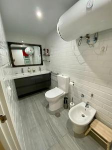 uma casa de banho branca com um WC e um lavatório em Duplex acogedor y cómodo em San Sebastián de los Reyes