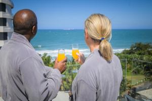 a man and a woman holding glasses of orange juice at The Capital Pearls Hotel in Durban