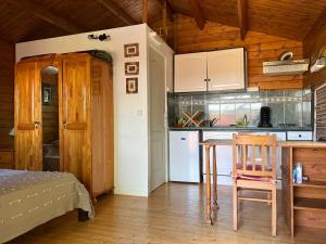 a kitchen with a table and chairs in a room at L'Ilot Zoizeaux in Les Avirons