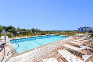 a swimming pool with chaise lounge chairs and a deck at Dune Crest Hotel in North Truro