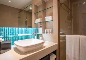 ein Badezimmer mit Waschbecken und Dusche in der Unterkunft Radisson Resort and Suites Phuket in Kamala Beach