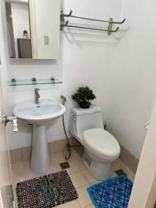 a bathroom with a toilet and a sink and a mirror at 2 Bedroom Condo Unit in Manila