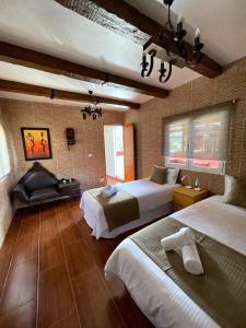 Habitación de hotel con 2 camas y chimenea en Villa Aguacate, en Teror