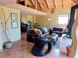 a living room with a couch and a table at Elgin Estate Lodge Nature View Loft in Grabouw