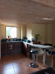 a kitchen with a counter and a table with stools at Essenhout Self-catering Accommodation in Grabouw