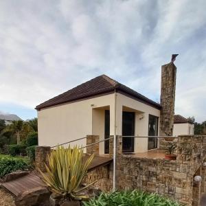 una casa con una pared de piedra en Essenhout Self-catering Accommodation en Grabouw