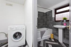 a bathroom with a washing machine and a sink at The Station House in Preston