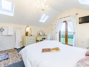 a bedroom with a white bed and a window at Hayloft- Uk31532 in Goxhill