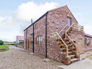 um edifício de tijolos com uma escada ao lado em Hayloft- Uk31532 em Goxhill