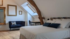um quarto com uma cama e uma cadeira azul em Le 14 Faubourg em Beaune