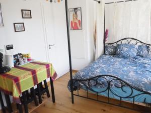 a bedroom with a iron bed and a table at Les Halles : Studio Cosy et Moderne in Strasbourg