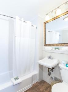 a white bathroom with a sink and a shower at Provincetown Inn in Provincetown