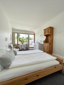 a bedroom with a large bed and a kitchen at Casa Las Caglias in Flims