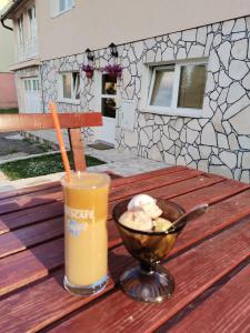 een drankje en een kom ijs op een houten tafel bij Apartment Kalpačina in Žabljak