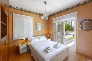 a bedroom with a bed and a sliding glass door at Beachfront Villa Carpe Diem in Kiti