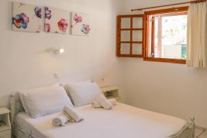 Un dormitorio con una cama blanca con toallas. en Villa Amy en Achladies