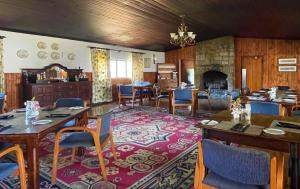 a dining room with tables and chairs and a fireplace at Himeville Arms in Himeville