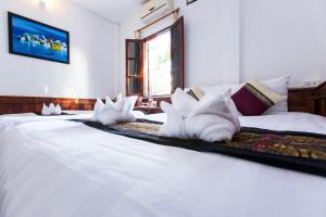 a large white bed with white pillows on it at Moon's house LuangPrabang in Luang Prabang