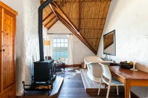 uma sala de estar com um fogão a lenha num quarto em The Farmhouse Hotel em Langebaan