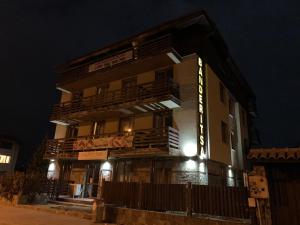 a tall building with a sign on it at night at Banderitsa Apartments with kitchen & BBQ in Bansko