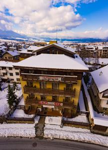 a yellow building with snow on the roof at Banderitsa Apartments with kitchen & BBQ in Bansko