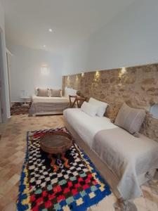 um quarto com uma cama, uma mesa e um sofá em Dar YAMAR em Essaouira