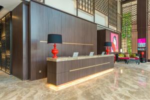 a lobby with a reception desk with two lamps at Ashley Tang Menteng Jakarta in Jakarta