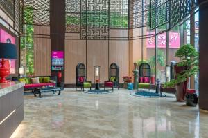 a lobby with chairs and tables in a building at Ashley Tang Menteng Jakarta in Jakarta