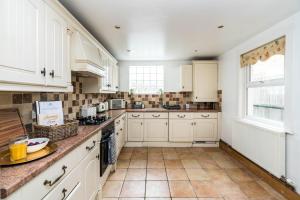 a kitchen with white cabinets and a tile floor at Edridge Lodge Photo ID & Deposit Required in Croydon