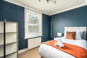 a bedroom with blue walls and a bed with an orange blanket at Edridge Lodge Photo ID Required in Croydon