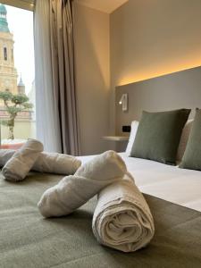 a towel laying on a bed in a hotel room at VTZ Hotel San Valero in Zaragoza