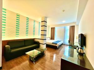 a living room with a couch and a bed at New World Express Motel in Bintulu