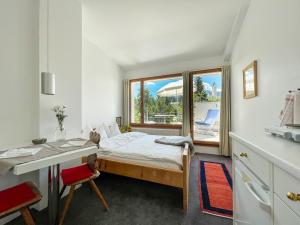a bedroom with a bed and a desk and a window at Casa Las Caglias in Flims
