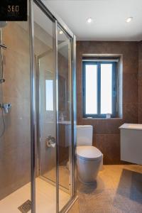 a bathroom with a toilet and a glass shower at High-End central APT with comfy BED & Super WIFI by 360 Estates in San Ġwann
