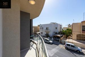 a balcony with a view of a parking lot at High-End central APT with comfy BED & Super WIFI by 360 Estates in San Ġwann